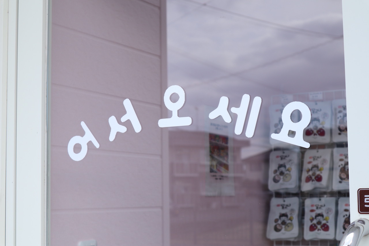 窓ガラスに韓国語でいらっしゃいませと書いてある